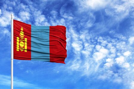 National flag of Mongolia on a flagpole in front of blue skyの写真素材