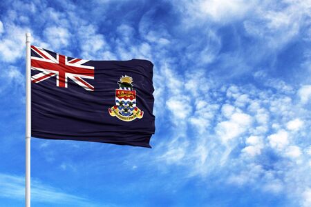 National flag of Cayman islands on a flagpole in front of blue skyの写真素材