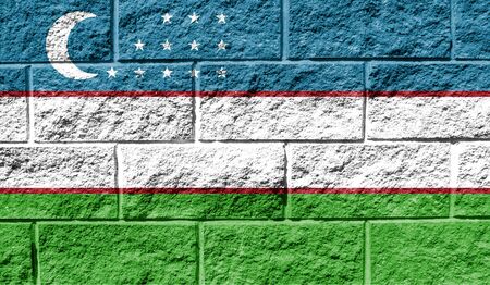 Flag of Uzbekistan close up painted on a cracked wallの写真素材