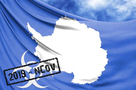 Novel coronavirus disease named 2019-nCoV with Antarctic flag closeup on blue sky backgroundの写真素材