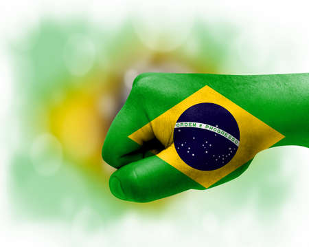 Flag of Brazil painted on male fist, strength, power, concept of conflict. On a blurred background.の写真素材
