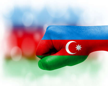 Flag of Azerbaijan painted on male fist, strength, power, concept of conflict. On a blurred background.の写真素材