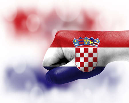 Flag of Croatia painted on male fist, strength, power, concept of conflict. On a blurred background.の写真素材