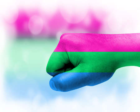 Flag of Polysexuality painted on male fist, strength, power, concept of conflict. On a blurred background.の写真素材
