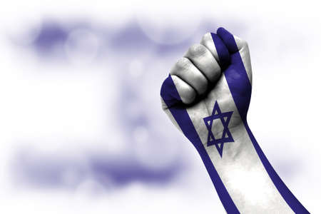 Flag of Israel painted on male fist, strength, power, concept of conflict. On a blurred background.の写真素材
