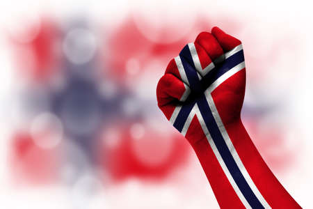 Flag of Norway painted on male fist, strength, power, concept of conflict. On a blurred background.の写真素材
