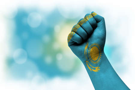 Flag of Kazakhstan painted on male fist, strength, power, concept of conflict. On a blurred background.の写真素材
