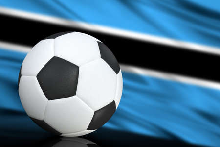 Soccer black and white ball close up, in the background a blurred flag of Botswana. The image takes place for your text.の写真素材