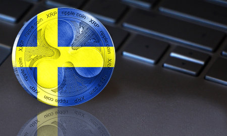 Coin Ripple (XRP) with the flag of Sweden depicted on it. In the background a keyboard with a good place for your text. New cryptocurrency, business concept.の写真素材