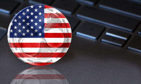 Coin Ripple (XRP) with the flag of America depicted on it. In the background a keyboard with a good place for your text. New cryptocurrency, business concept.の写真素材