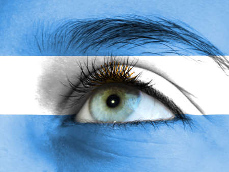 Close up view of a young girl. The flag of Argentina is painted on the girl face.の写真素材