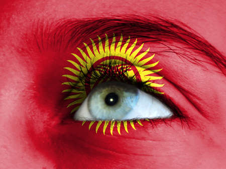 Close up view of a young girl. The flag of Kyrgyzstan is painted on the girl face.の写真素材