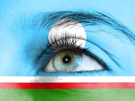Close up view of a young girl. The flag of Sakha Republic is painted on the girl face.の写真素材