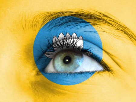 Close up view of a young girl. The flag of Kalmykia is painted on the girl face.の写真素材