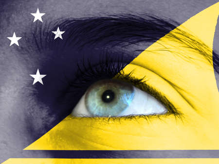 Close up view of a young girl. The flag of Tokelau is painted on the girl face.の写真素材
