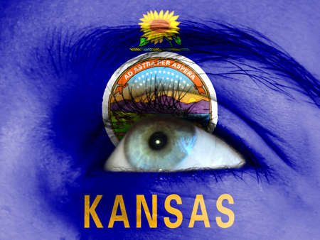 Close up view of a young girl. The flag State of Kansas is painted on the girl face.の写真素材