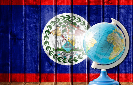 Globe with a world map on a wooden background with the image of the flag of Belize. The concept of travel and leisure abroad.の写真素材