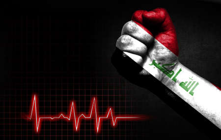 Flag of Iraq painted on male fist, the concept image shows the strength of medicine or politics in countries, photography has a good place for your text.の写真素材