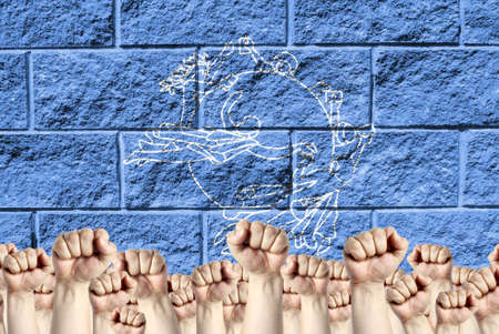 Raised fists against the background of the depicted flag of UPU on a brick wall, a concept of strength and unity.の写真素材