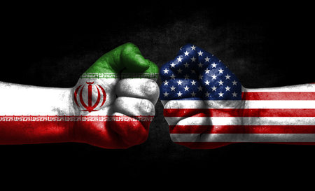 The concept of the confrontation of peoples. The two fists are opposite each other. The hands are painted in the colors of the flags of the countries. America versus Iranの写真素材