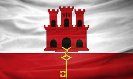 Realistic flag of Gibraltar on the wavy surface of fabricの写真素材