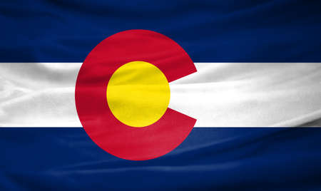 Realistic flag of State of Colorado on the wavy surface of fabricの写真素材