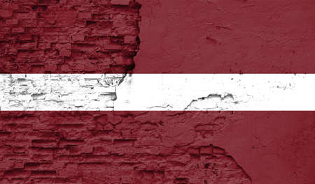 Latvia flag is painted onto an old brick wallの写真素材