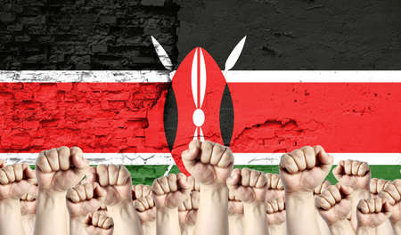 Raised fists of men against the background of the flag of Kenya painted on the wall, the concept of popular unity and the opinion of the majority.の写真素材
