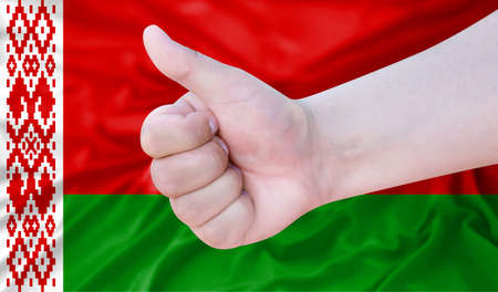 Hand makes a thumbs up sign on the background of the flag of Belarus. like, good, positiveの写真素材