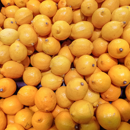 Many juicy bright yellow lemons on a market counter. Close-up. Background.の写真素材