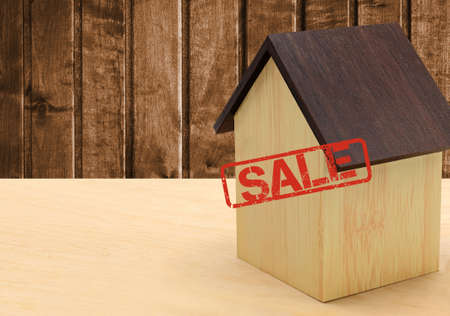 A small wooden house is placed on the tableの写真素材