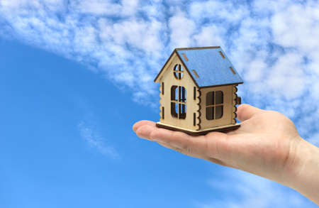 Wooden house in the palm of your hand, property sale conceptの写真素材
