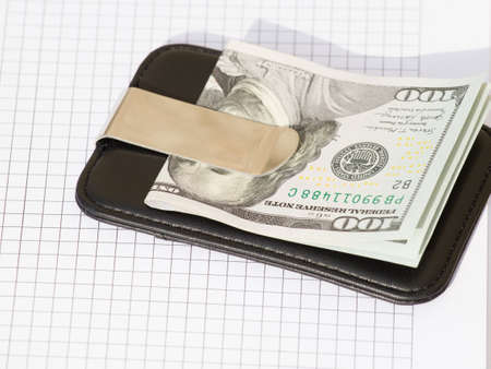 US dollars in a black wallet isolated on white background