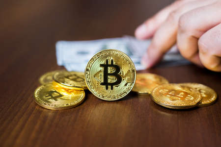 Cryptocurrency bitcoin close-up, in the background american dollarsの写真素材