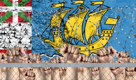 Raised fists against the background of the depicted flag of Saint Pierre and Miquelon behind barbed wire.の写真素材