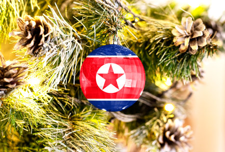 New Year's glass ball with the flag of North Korea against a colorful Christmas backgroundの写真素材
