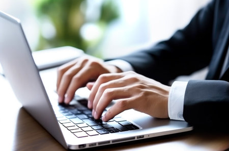 Close up of man hands typing text on laptop keyboard sitting at wooden table. Made with AI generationの素材