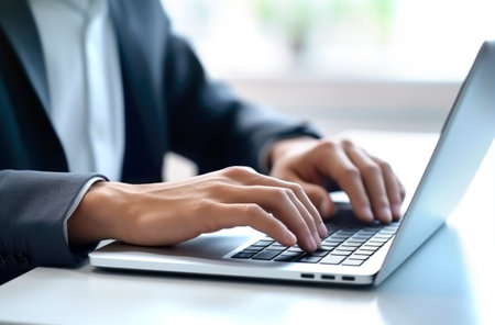 Close up of man hands typing text on laptop keyboard sitting at wooden table. Made with AI generationの素材