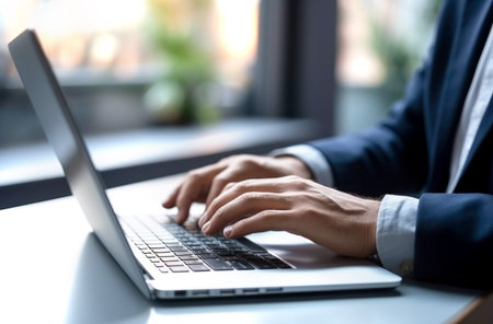 Close up of man hands typing text on laptop keyboard sitting at wooden table. Made with AI generationの素材