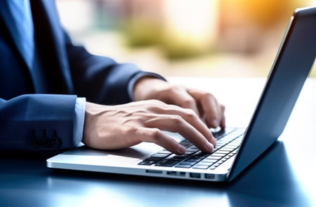 Close up of man hands typing text on laptop keyboard sitting at wooden table. Made with AI generationの素材