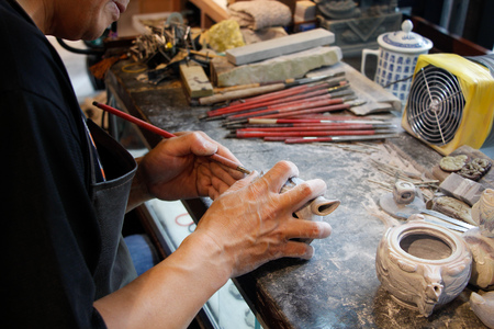 Close up view of a man carving on a stone in making a chopの写真素材