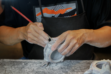 Close up view of a man carving on a stone in making a chopの写真素材