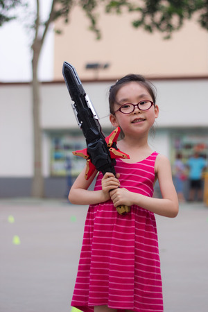 Cute little girl holding a toy swordの写真素材