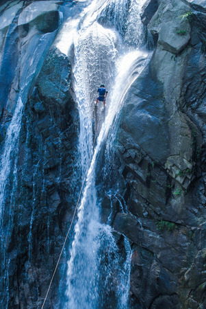 Rock climbing on a waterfallの写真素材