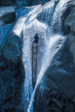 Rock climbing at a waterfallの写真素材