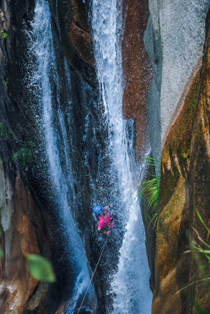 Rock climbing down the waterfallの写真素材