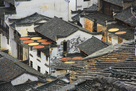 Villagers drying harvested crops on top of the roofの写真素材