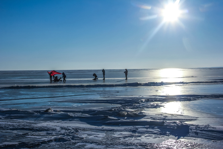 People playing at frozen lakeの写真素材