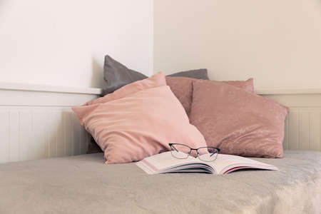A corner for rest, reading a book, studying, relaxing, or other pleasant moments. Sofa with soft pillows and a warm blanket.の写真素材