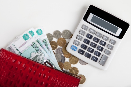 purse with paper money and coins, calculator on a whiteの写真素材